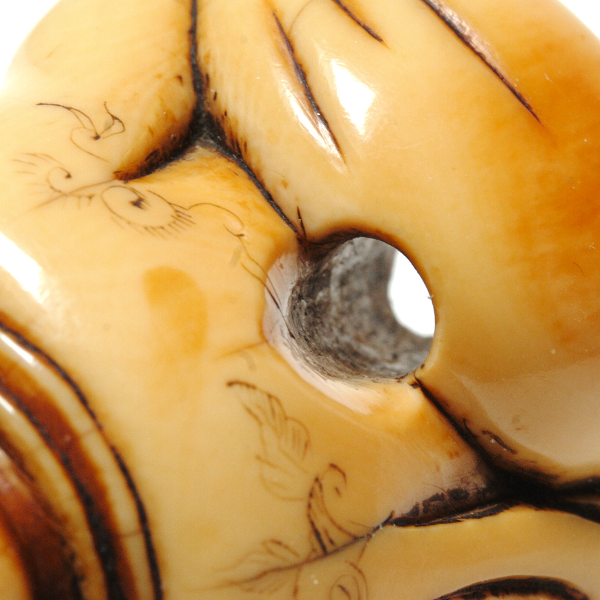AN IVORY NETSUKE FIGURE OF HOTEI