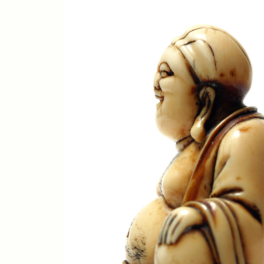 AN IVORY NETSUKE FIGURE OF HOTEI